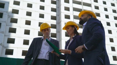 Three serious business man at a construction site on a building background. Men Stock Footage 89217347
