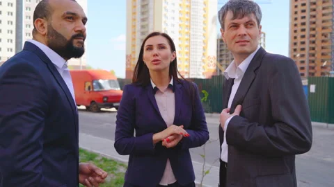 Three serious businessmen two men and a woman discussing a project under Stock Footage 89030682