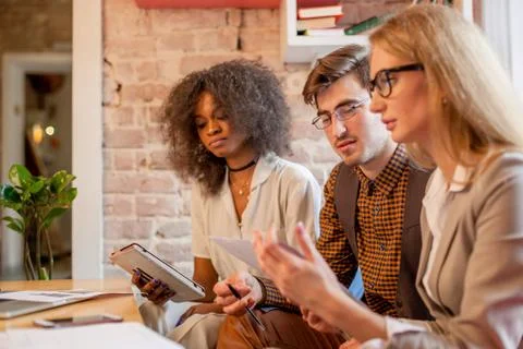 Three serious friends solving some bussines problems in their office. Stock Photos