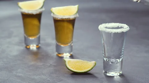 Three shot gold tequila on a black background ,selective focus Stock Footage