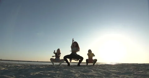 Three silhouettes of girls dancing synchronously on the beach Stock-Footage 146837853