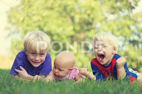 Three silly Children Relaxing Outside Stock Photos