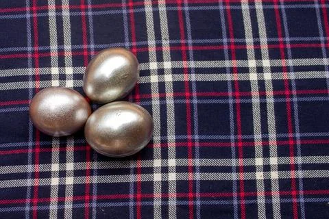 Three Silver Easter Eggs on Navy Plaid Fabric Background Stock Photos