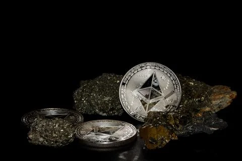 Three silver ether coins from ethereum currency and minerals with iron on bla Stock Photos