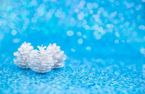 Three silver glittery pinecones on blue Stock Photos