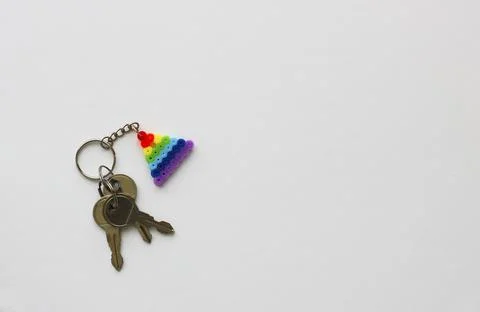 Three silver keys with a rainbow triangle pendant made of perler beads Stock Photos