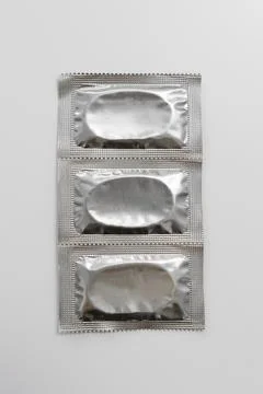 Three silver packages condoms with copyspace Stock Photos