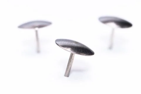 Three Silver Thumb Tacks on a White Background, Close-Up View, Office Supplie Stock Photos