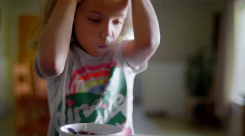 Three sisters sitting at a kitchen counter eating cereal Stock Footage 55768405