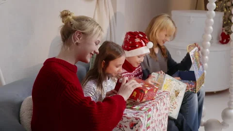 Three sisters unwrapping christmas presents together Stock Footage 295794635
