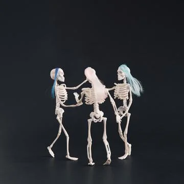Three skeletons like three graces dancing on a black background. Foto stock