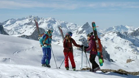 Three skiers give high five to each other on snowy mountain peak Stock Footage 116787996