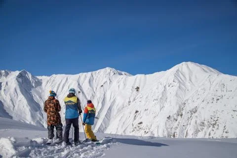 Three skiers standing on top of freeride zone in Gudauri mountains, Georgia Stock Photos