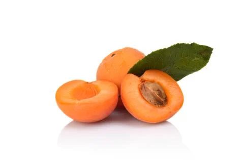 Three sliced apricots with leaf isolated on white background Stock Photos