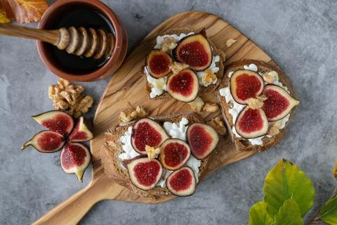 Three slices of bread with figs and cheese on top Stock Photos