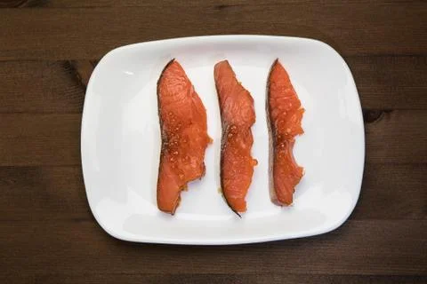 Three slices of fish on a plate Stock Photos