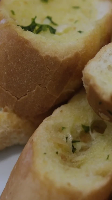 Three slices of garlic bread with fresh parsley on a white ceramic plate Stock Footage 310158038