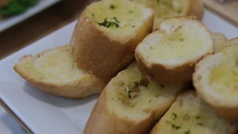 Three slices of garlic bread with fresh parsley on a white ceramic plate Stock Footage 310158135