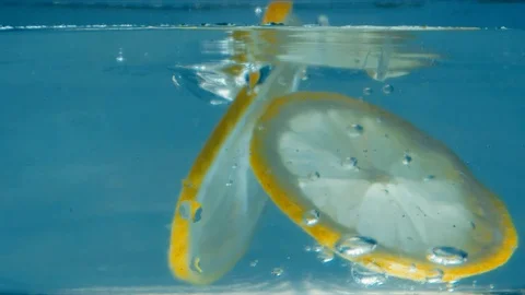 Three slices of lemon fall into the water Stock Footage 117399121
