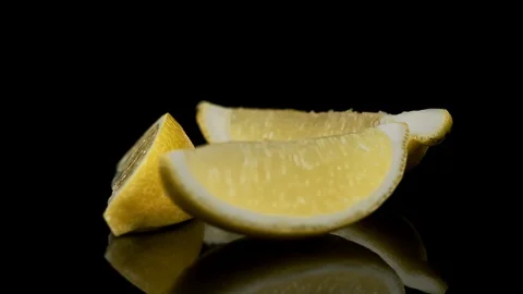 Three slices of lemon rotating on a black background 動画素材 128721101