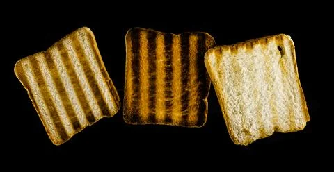 Three slices of toasted bread on the grill on a black background. Toast bread. 库存照片