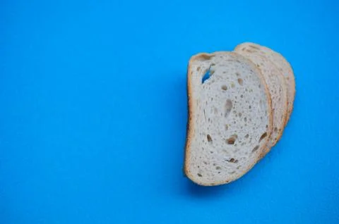 Three slices of white wheat bread on blue background, front view Stock Photos