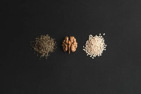 Three slides of green thyme, half of walnut and white sesame. Stock Photos