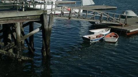 Three small boats docked in a harbor by a pier  Stock Footage 81561441