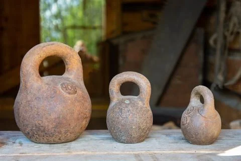 Three small calibration weights standing on wooden background Stock Photos