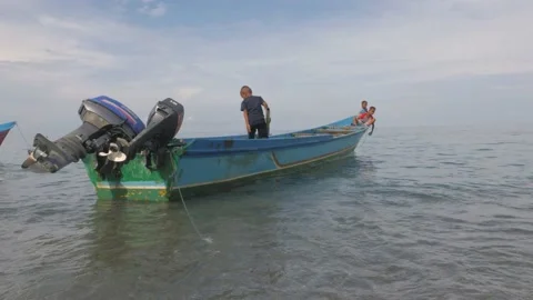 Three small children play on a small wooden boat by the sea Stock Footage 130903416