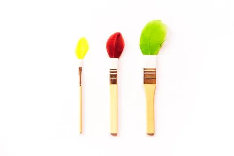Three small children's brushes for artwork with multi-colored painted feathers Foto stock