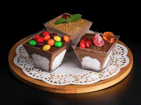 Three small chocolate dessert cups topped with fresh strawberries and mint le Stockfoto's