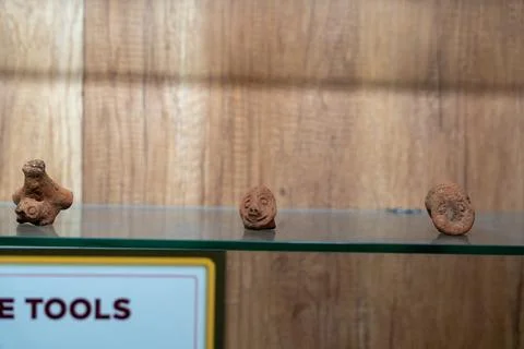 Three small clay figures are displayed on a glass shelf. in Chennai Photos