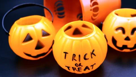 Three small empty plastic pumpkin baskets for trick and treat on black. backg Stock Photos