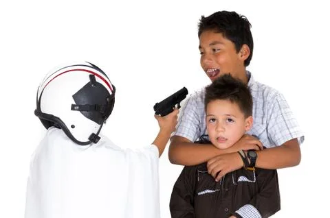 Three small hispanic boys playing in front of white background, two are holding Stock-Fotos