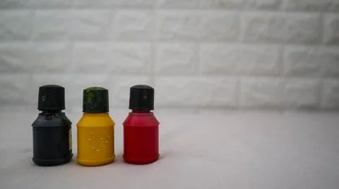 Three small paint bottles in black, yellow, and red colors are arranged in .. Foto stock