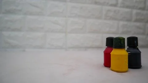 Three small paint bottles in black, yellow, and red colors are arranged in .. Foto stock