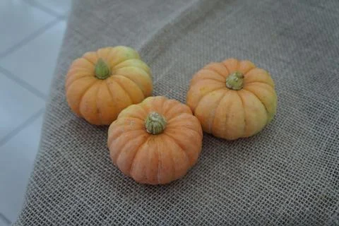 Three small pumpkins on burlap Stock Photos
