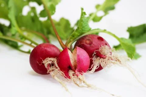 Three small radishes on a white background, one of which is cracked as a resu Free Stock Photos