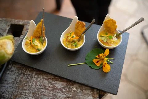 Three small samples of yellow ceviche on slate graphite surface in peruvian.. Foto stock