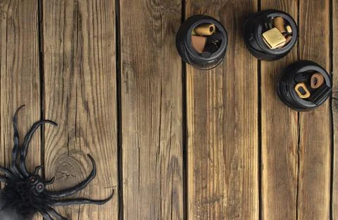 Three small toy witch's cauldrons with different sweets are on a wooden table Stock Photos