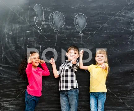 Three smiling children with thumbs up keeping imaginaru drawn balloons Stock Photos