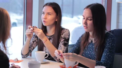 Three smiling girlfriends drink coffee and communicate 스톡 동영상 60729113