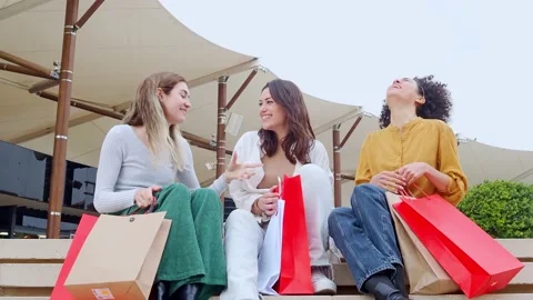 Three smiling multi-ethnic female friends with shopping bags in a mall. Stock Footage 215685391