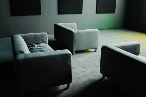 Three Sofas Placed in an Dark Entertainment Room with a Bright Light Coming.. Stock Photos
