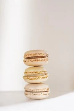 Three soft beige pastel macarons stacked Foto stock