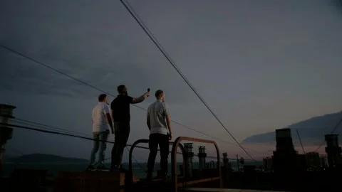 Three specialists stand on the roof of a multi-storey building Stock Footage 151646360