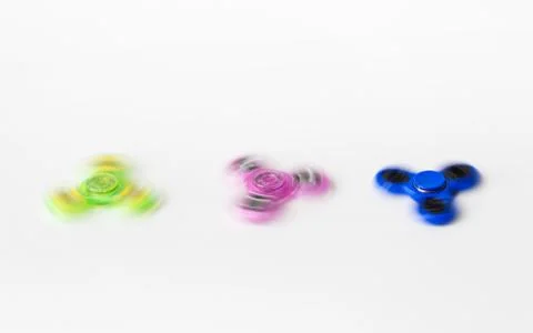 Three spinning fidget spinners on white background Stock Photos