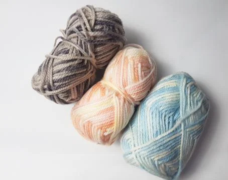 Three spools of knitting thread, colored blue, orange and gray isolated on .. Stock Photos