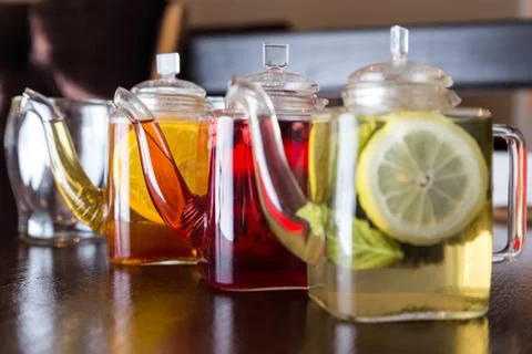 Three square teapots with different fruit tastes of tea Foto stock